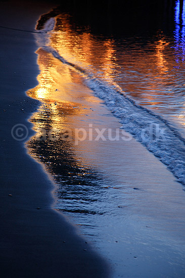 Reflektioner. Lys reflekteres i v�dt sand i br�ndingen p� sandstrand; ; Sorrento; Italien; Europa; ; farve, farver, stemninger, stemning, br�nding, b�lger, romantik, vand