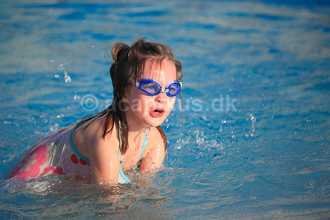 Badeliv. Syv�rig pige boltrer sig i swimmingpoolen p� feriehotel p� Mallorca. Model release OK.; ; Cales de Mallorca / Mallorca; Spanien; ; ; Swimmingpools, swimmingpool, sv�mning, sv�mmebriller, sommerferie, ferier, ferie
