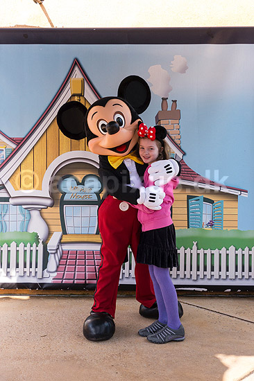 Disneyworld. Pige opstillet til fotografering med Mikey Mouse i Disneyworld i Paris. Model release for pige.; ; Paris; Frankrig; ; ; Eurodisney, Disneyland Park, Forlystelsespark, forlystelsesparker