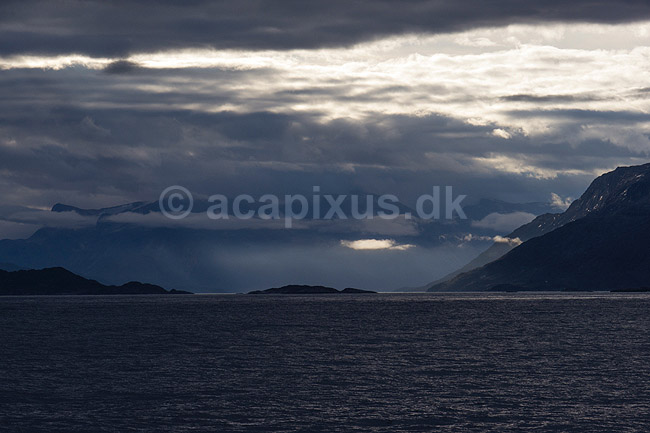 Gr�nland. Gr�nlands kyst set fra kystf�rgen mellem Ililissat og Nuuk. Solen skinner ned mellem skyer p� havets overflade; ; ; Gr�nland; ; ; 