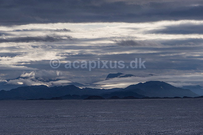 Gr�nland. Gr�nlands kyst set fra kystf�rgen mellem Ililissat og Nuuk. Solen skinner ned mellem skyer p� havets overflade; ; ; Gr�nland; ; ; 