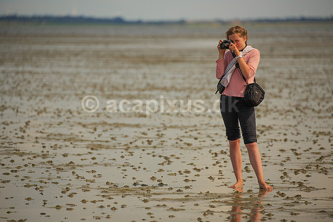 R�m�. Ung pige (model release OK) fotograferer p� vaden ved S�nderstrand; ; R�m�; Danmark; ; ; fotograf, fotografering, naturfotografering