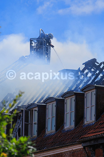 Husbrand. Brandslukker i r�gdragt slukker tagbrand i gammelt hus i Skolegade i Ribe; ; Ribe; Danmark; ; ; Brand, ildebrand, brandslukning, forsikring, brandforsikring