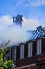Husbrand. Brandslukker i r�gdragt slukker tagbrand i gammelt hus i Skolegade i Ribe  Ribe Danmark   Brand, ildebrand, brandslukning, forsikring, brandforsikring