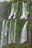 Iguazu vandfaldene. Iguazu vandfaldene fosser over mosbegroet klippeside - set fra den Argentinske side af vandfaldene - til h�jre Argentina til venstre Brasilien  Iguazu Argentina Sydamerika  Vandfald, The Iguazu Falls, Iguaz� Falls, Iguassu Falls, Igua�u Falls, Cataratas del Iguaz�, Cataratas do Igua�u 