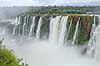 Iguazu vandfaldene. Iguazu vandfaldene fosser over mosbegroet klippeside - set fra den Argentinske side af vandfaldene - til h�jre Argentina til venstre Brasilien  Iguazu Argentina Sydamerika  Vandfald, The Iguazu Falls, Iguaz� Falls, Iguassu Falls, Igua�u Falls, Cataratas del Iguaz�, Cataratas do Igua�u 