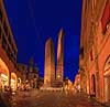 Bologna. Le due torri (De to T�rne) i Bologna, hhv Asinelli Tower (70 m) og Garisenda Tower (48 m), som begge er sk�ve. De h�lder hhv 2,2 og 3,2 meter.  Piazza Di Porta Ravegnana / Bologna Italien   