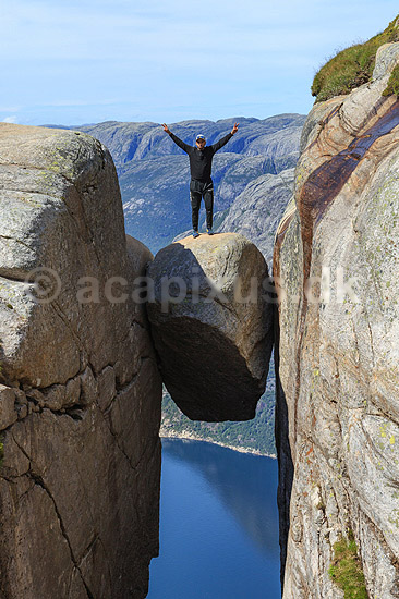 Kjeragbolten. Fjeldvandrer p� Kjeragbolten, en stor sten klemt fast imellem to klippesider 1000 meter (ja) over Lysefjord; ; Kjerag / Stavanger; Norge; ; ; Vandring, vandretur, fjeldvandring, turisme, hiking