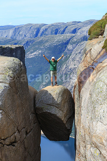Kjeragbolten. Fjeldvandrer p� Kjeragbolten, en stor sten klemt fast imellem to klippesider 1000 meter (ja) over Lysefjord; ; Kjerag / Stavanger; Norge; ; ; Vandring, vandretur, fjeldvandring, turisme, hiking