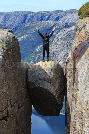 Kjeragbolten. Fjeldvandrer p� Kjeragbolten, en stor sten klemt fast imellem to klippesider 1000 meter (ja) over Lysefjord; ; Kjerag / Stavanger; Norge; ; ; Vandring, vandretur, fjeldvandring, turisme, hiking