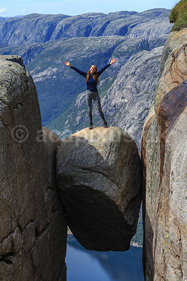Kjeragbolten. Fjeldvandrer p� Kjeragbolten, en stor sten klemt fast imellem to klippesider 1000 meter (ja) over Lysefjord; ; Kjerag / Stavanger; Norge; ; ; Vandring, vandretur, fjeldvandring, turisme, hiking