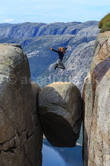 Kjeragbolten. Fjeldvandrer p� Kjeragbolten, en stor sten klemt fast imellem to klippesider 1000 meter (ja) over Lysefjord; ; Kjerag / Stavanger; Norge; ; ; Vandring, vandretur, fjeldvandring, turisme, hiking