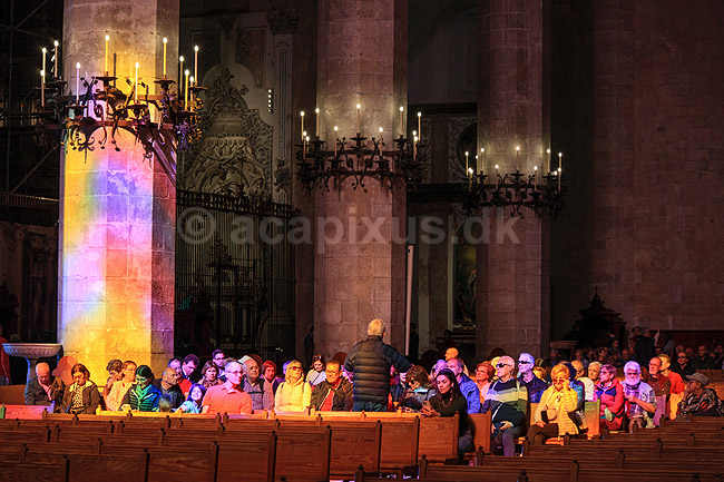 Domkirken i Palma de Mallorca. Bes�gende sidder i farvede solstr�ler der skinner gennem de farvede glasmosaik vinduer i Catedral-Bas�lica de Santa Mar�a de Mallorca - domkirken - i Palma de Mallorca; ; Palma de Mallorca; Spanien; ; Sev�rdigheder; Kirke, kirker, domkirker, kristendom, katolsk, religion, kirkeg�ngere