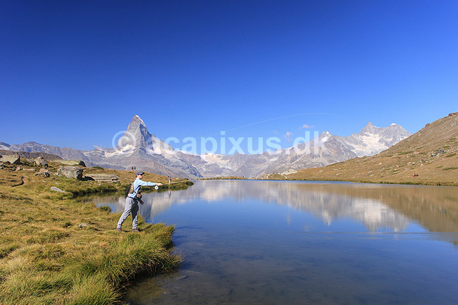 Matterhorn. Fluefisker fisker �rreder i  bjergs�en Stellisee med det ikoniske bjerg Matterhorn i baggrunden; ; Zermatt; Schweiz; ; ; Alperne, bjerglandskab, Alpelandskab, bjergvandring
