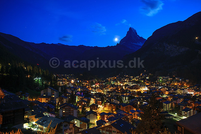 Matterhorn og Zermatt. Zermatt og Matterhorn i skumringen med m�nen p� vej til at g� ned bag bjerget; ; Zermatt; Schweiz; ; ; Alperne, bjerglandskab, Alpelandskab