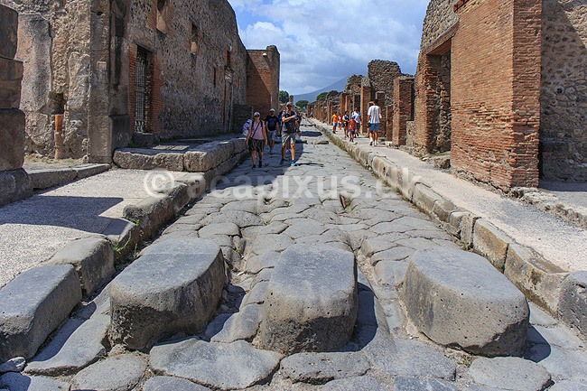 Pompeji. Fodg�ngerfelt med plads til oksek�rrehjul p� brostensgade i Pompeji; ; Pompeji / Pompei / Pompeii / Napoli / Campania; Italien; ; ; Ark�ologi, vulkaner, vulkanudbrud, pyroplastisk flow, pyroplasma, Vesuvius, Vesuv, naturkatastrofer, turistsev�rdigheder, sev�rdigheder, turisme, Romerriget, romerne, ruiner, ruinbyer