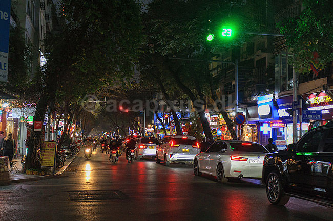Hanoi. Cyklist cykler med sin tungt lastede cykel mellem scootere og biler i aftentrafikken i Hanoi; ; Hanoi; Vietnam; ; ; Trafik, scootere, kaos