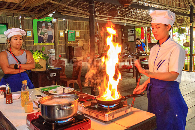 Madlavningskursus i Hoi An. Kok flamberer en ret ved madlavningskursus i Hoi An, der kom p� UNESCO World Heritage Site listen i 1999 og derefter blev en mega turistattraction; ; Hoi An; Vietnam; ; Sev�rdigheder; madlavning, k�kken, kogekunst