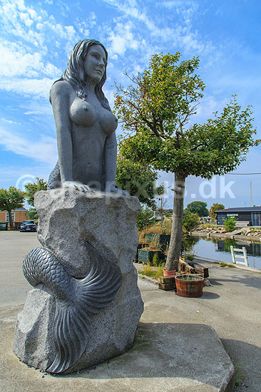 Den Store Havfrue statue p� Drag�r Havn. Den Store Havfrue, bestilt af Peter Bech, udf�rt i Kina i kinesisk granit, blev i 2006 rejst over for skulpturen Isbj�rn med unger p� Langeliniekajen og blev i 2018 flyttet til Drag�r Fort. Blev i 2025 anklaget for at v�re sexistisk, pornografisk og vulg�r og Drag�r Kommune �nsker den fjernet. Alle adspurgte under fortograferingen anser den dog som smuk og mener den om noget skulle have en mere fremtr�dende plads.; ; Drag�r; Danmark; ; sev�rdigheder; Havfruer, skulpturer